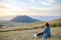 Lonely girl sitting next to Komezuka of Mount Aso Aso-san Royalty Free Stock Photo