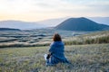 Lonely girl sitting next to Komezuka of Mount Aso Aso-san Royalty Free Stock Photo