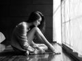 Lonely girl sitting sadly by the window in the bedroom Royalty Free Stock Photo