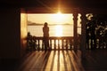 Lonely girl is standing on the terrace and admires the setting sun