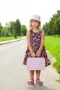 Girl with suitcase standing on road Royalty Free Stock Photo