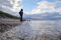 A lonely girl travels along the shore. Active rest outside the city. Wildlife. Bad weather