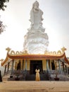 Lonely girl wearing yellow dress in Ho Quoc Pagoda With Guan Yin Statue Overlooking the Sea, Phu Quoc Island, Vietnam