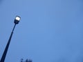 Lonely glowing street lamp against the grey winter sky Royalty Free Stock Photo