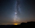 Lonely guy watching the Milky Way from a mountain ridge