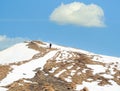 Lonely hiker walking on the snowy mountain. Winter landscape in Carpathian Mountains, Romania Royalty Free Stock Photo