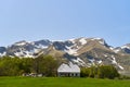 A lonely house in a green meadow against the backdrop of a mountain with snow. Montenegro Royalty Free Stock Photo