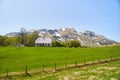 A lonely house in a green meadow against the backdrop of a mountain with snow. Montenegro Royalty Free Stock Photo