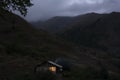 Lonely house in the mountains. Beautiful mountain landscape with a small house. Light in the window of the house. Smoke comes from Royalty Free Stock Photo