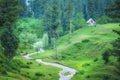 A lonely house situated at the top of a hill with a small stream flowing. lush green scenery Royalty Free Stock Photo