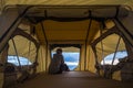 Lonely independent strong middle age woman feeling the nature outdoor in a roof tent on the car. travel and lifestyle wanderlust