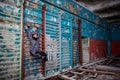 Lonely kid girl in abandoned old children school, oldish walls with cracked paints yellow blue green walls, forsaken strange left Royalty Free Stock Photo