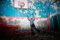 Lonely kid girl in abandoned old children school, oldish walls with cracked paints yellow blue green walls, forsaken strange left Royalty Free Stock Photo