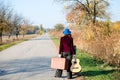 Lonely lady walking away with retro suitcase and