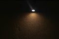 Lonely lamp illuminating brown concrete wall in absolute darkness Royalty Free Stock Photo