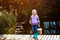 Lonely little child fishing from wooden dock on lake Royalty Free Stock Photo