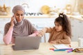 Lonely Little Girl Demanding Attention From Her Busy Muslim Freelancer Mom Royalty Free Stock Photo