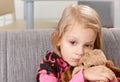 Lonely little girl sitting sadly on sofa Royalty Free Stock Photo