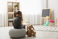 Lonely girl with toy bunny at home, back view. Autism concept Royalty Free Stock Photo