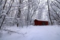 Lonely little red wooden cottage in a snowy northern forest in winter Royalty Free Stock Photo