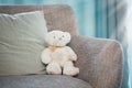 Lonely, loss and adoption with a teddy bear abandoned on a sofa in an empty living room of a home. Lost, alone and grief