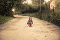 Lonely lost kid girl on rural road in countryside concept carefree childhood in countryside rustic lifestyle