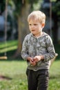 A lonely lost and worried little boy in a summer park Royalty Free Stock Photo