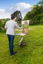 Lonely male artist working outdoors in the park or garden Royalty Free Stock Photo
