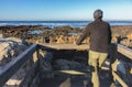 Lonely man from the back on the beach of Atlantic ocean, Portugal. Quiet morning on Atlantic ocean coast. Seascape with cliffs.