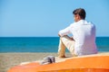 Lonely man on the beach above a boat looking at the sea Royalty Free Stock Photo
