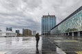 Lonely man in a city square on a rainy day