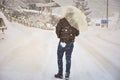 Lonely man holding umbrella with snow falling