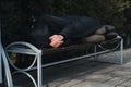 lonely man homeless and upset lies sleeping on park bench Royalty Free Stock Photo