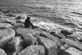Lonely man looking to sea on the rocks