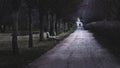 A lonely man passing by an empty bench in a park Royalty Free Stock Photo