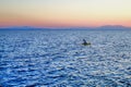 Lonely man in row boat on the sea at sunset Royalty Free Stock Photo