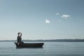 lonely man sailing lost in a small boat in the middle of the sea looking for himself Royalty Free Stock Photo