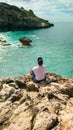 Lonely man on the seashore sitting on a rock. A young man dreams on the shore near the Black Sea in Europe