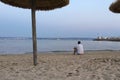 Lonely man sits on the beach looking at the sea