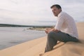 Lonely Man sitting on sand beach and watching far a way views alone. Royalty Free Stock Photo