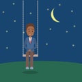 Lonely man sitting on a swing in the night