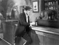 Lonely man standing at a bar counter with a drink Royalty Free Stock Photo