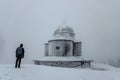 Lonely man standing on Radhost mountain looking to Chapel of St. Cyril and Methodius,Beskids,Czech republic.Silhouette of man in Royalty Free Stock Photo