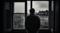 A lonely man stands in front of a window