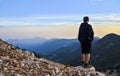 Lonely man stands high in the mountains and looks at sunset. The concept of tourism travel. Tahtali mountain, Turkey Royalty Free Stock Photo