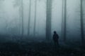 Lonely man, a man stands between tree trunks on a blurry background of a foggy forest, mysterious mystical concept