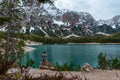 Lonely man traveler sit on the coast of alpine lake Lago di Braies in Dolomities mountains, Italy on moody spring day Royalty Free Stock Photo