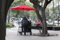 lonely man under the red umbrella in Mexico