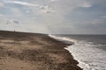 Lonely man walking at the beach. Cloudy