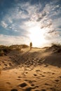 Lonely man walking in the desert dunes at sunset Royalty Free Stock Photo